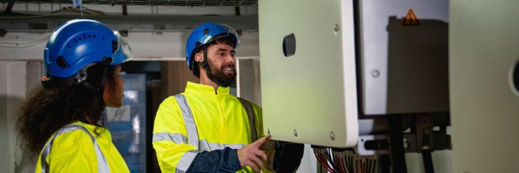 Man and women looking at corrosion on electrical enclosure